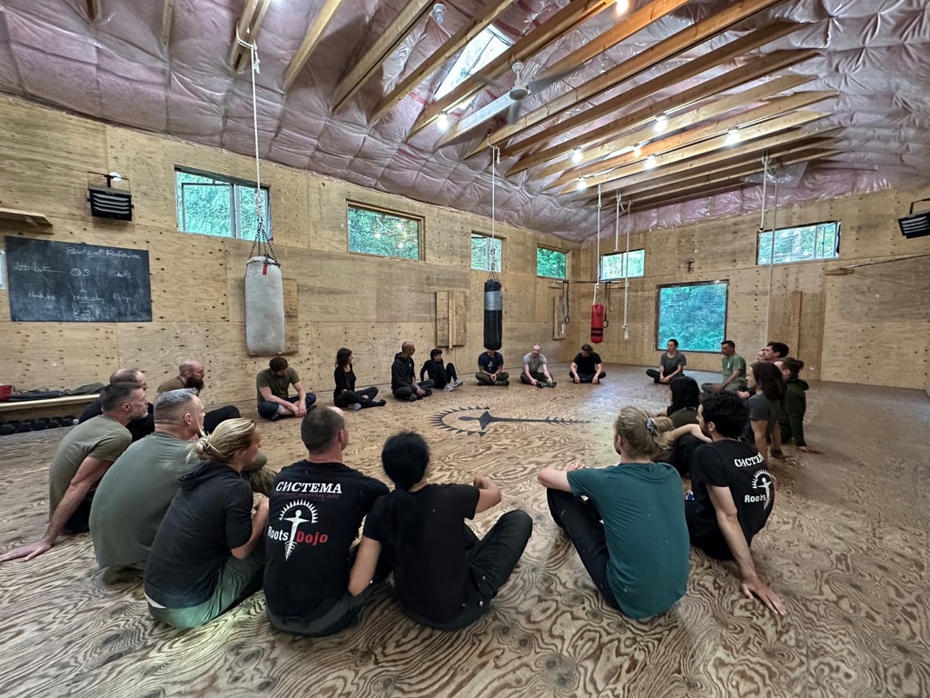 Students seated in a circle inside Roots Dojo