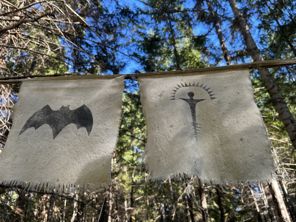 Fabric flags bearing symbols hanging in the forest