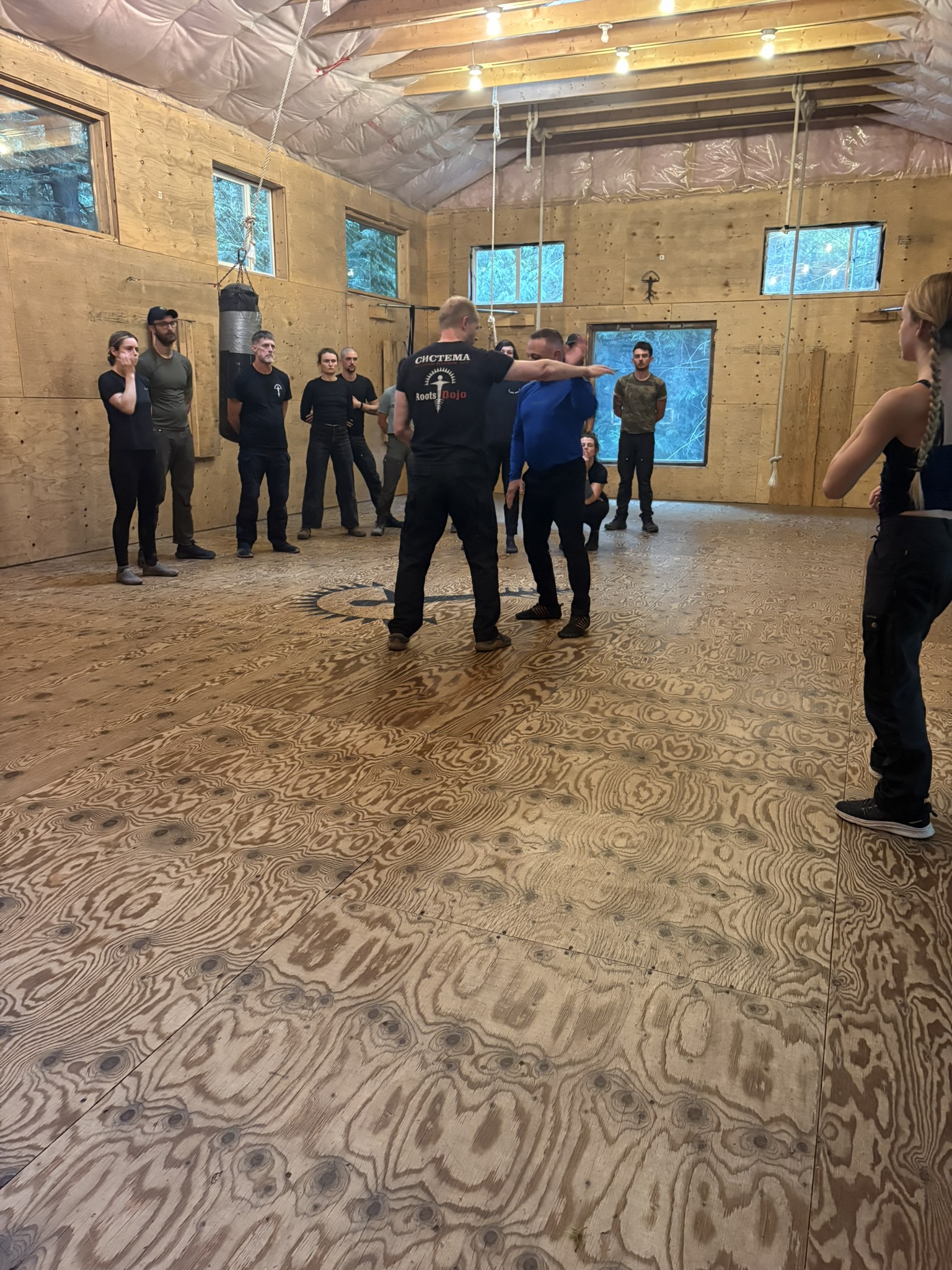 Standing martial arts demonstration with students watching